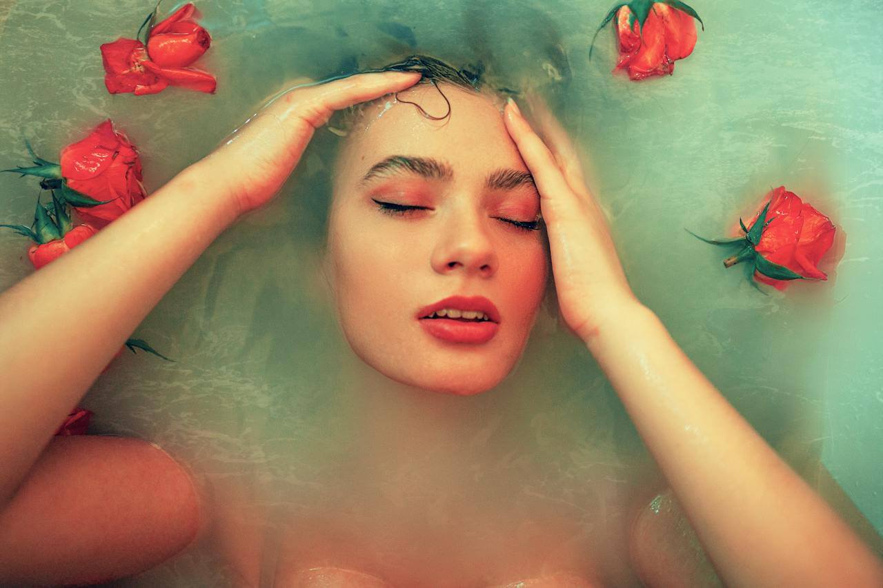 Mujer bañandose en agua de rosas